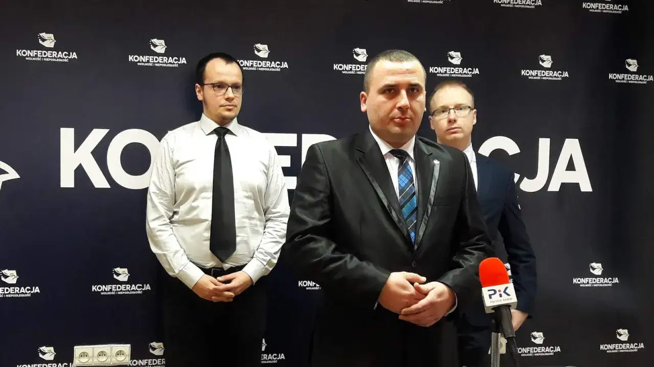Trzech mężczyzn w garniturach na tle logo Konfederacji. Prawdopodobnie omawiają, dlaczego Konfederacja krytykuje zmiany w zasadach amortyzacji aut spalinowych od 2026 roku.