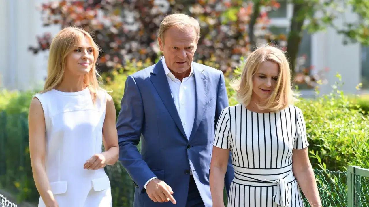 Donald Tusk z córkami, Katarzyną i Zofią, spacerują w słoneczny dzień.