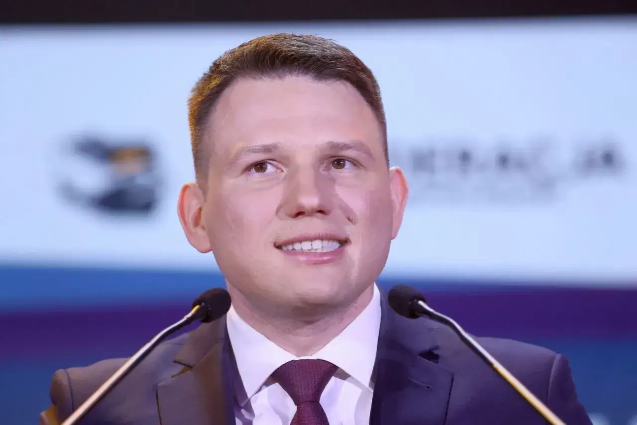 Słuchacz słucha przemówienia polityka, który wyjaśnia, dlaczego partia Mentzena chce podwyższenia limitu kasowego PIT do 2 mln złotych.