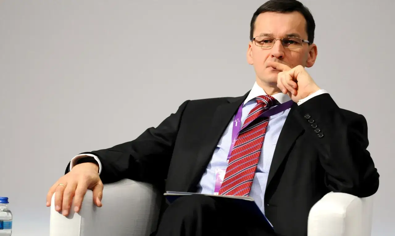 Mężczyzna w garniturze, z ręką na brodzie, zastanawia się nad pytaniem: ile zarabia Morawiecki?