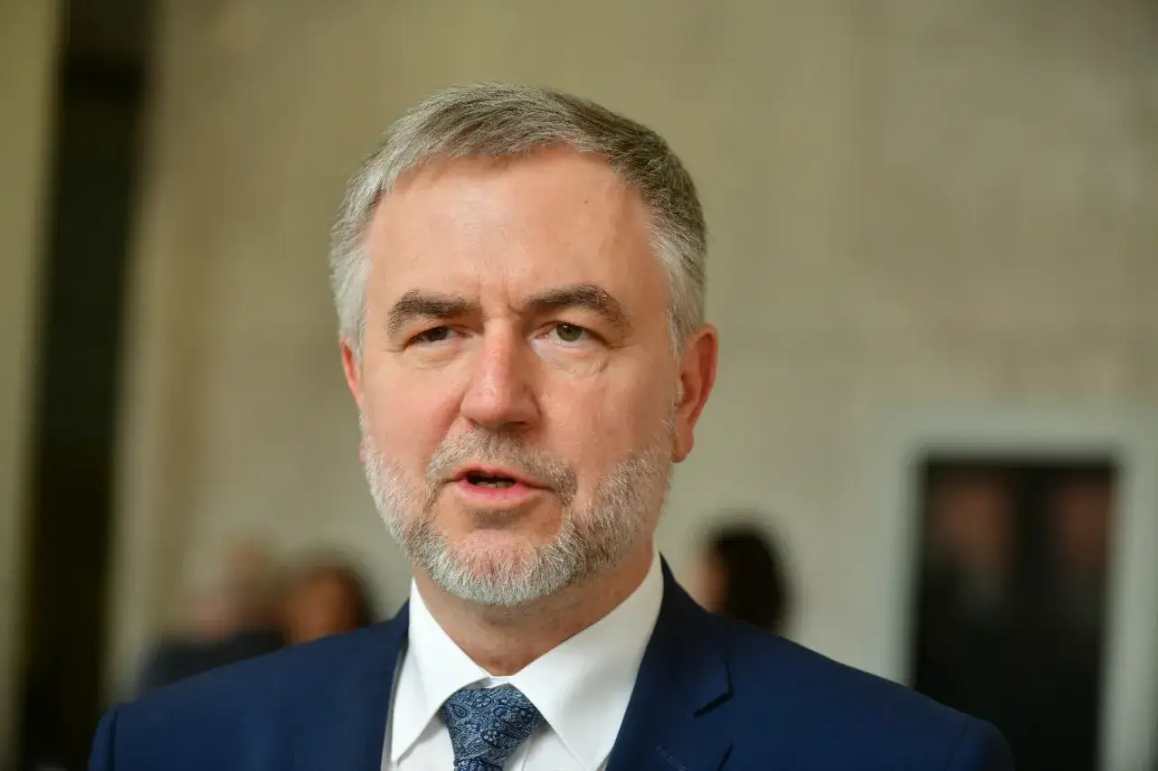 Marszałek Marek Woźniak, z siwiejącą brodą i w granatowym garniturze, mówi o tym, dlaczego marszałek Marek Woźniak unika konkursów na dyrektorów teatrów w Wielkopolsce.