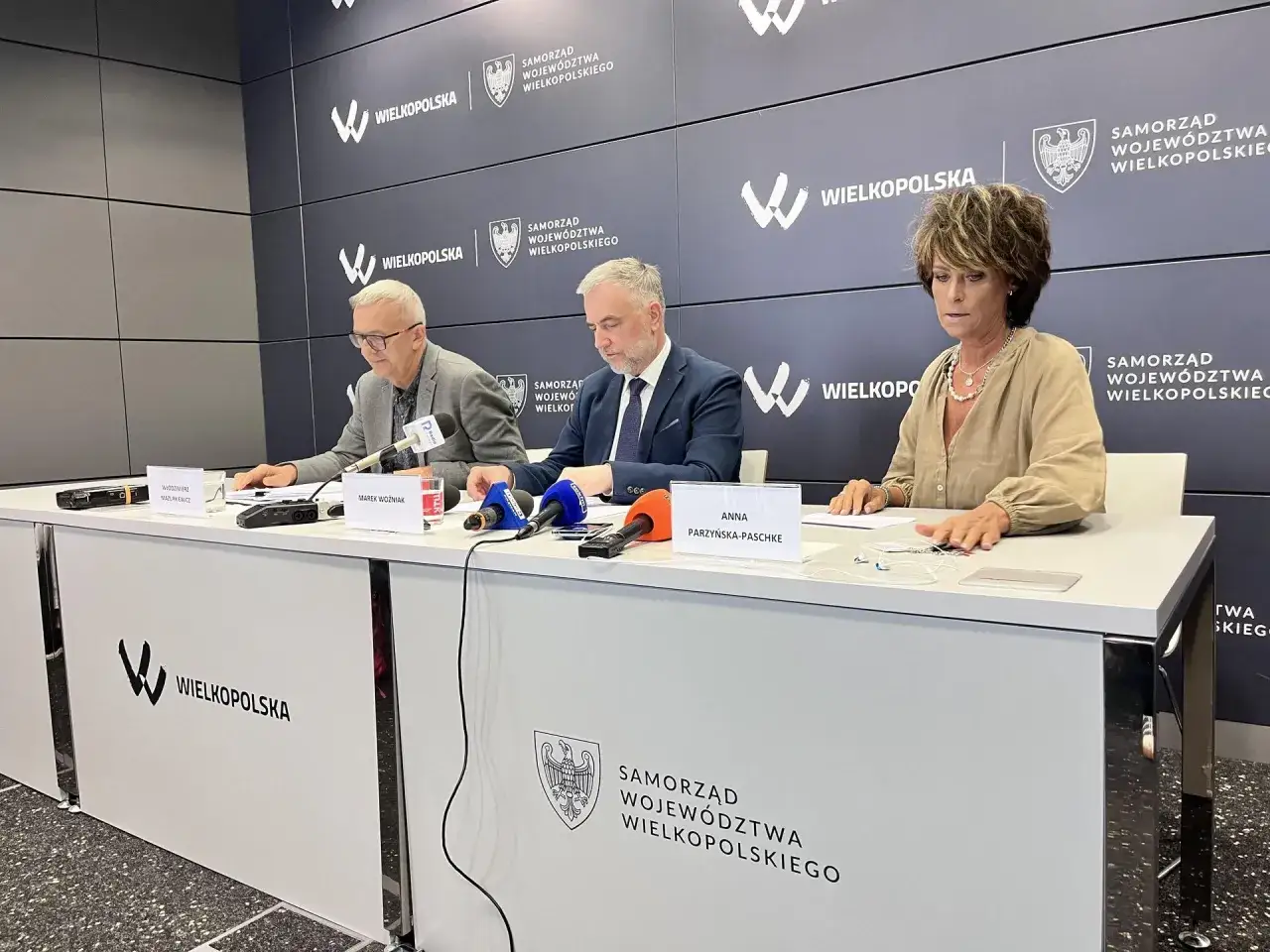 Trzech urzędników siedzi za stołem z mikrofonami. Czy to odpowiedź na pytanie, dlaczego marszałek Marek Woźniak unika konkursów na dyrektorów teatrów w Wielkopolsce?