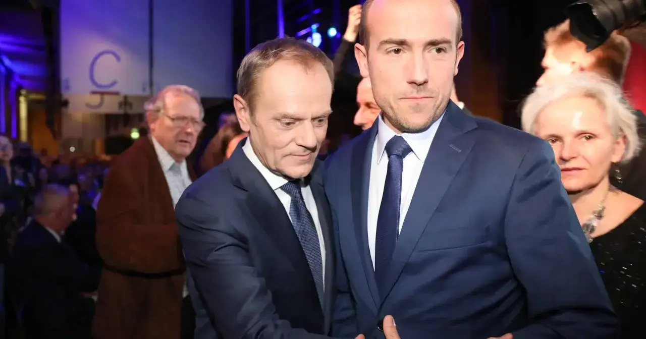 Kulisy decyzji o jedynej kandydaturze Donalda Tuska na przewodniczącego partii. Politycy w garniturach, w tle tłum i logo 