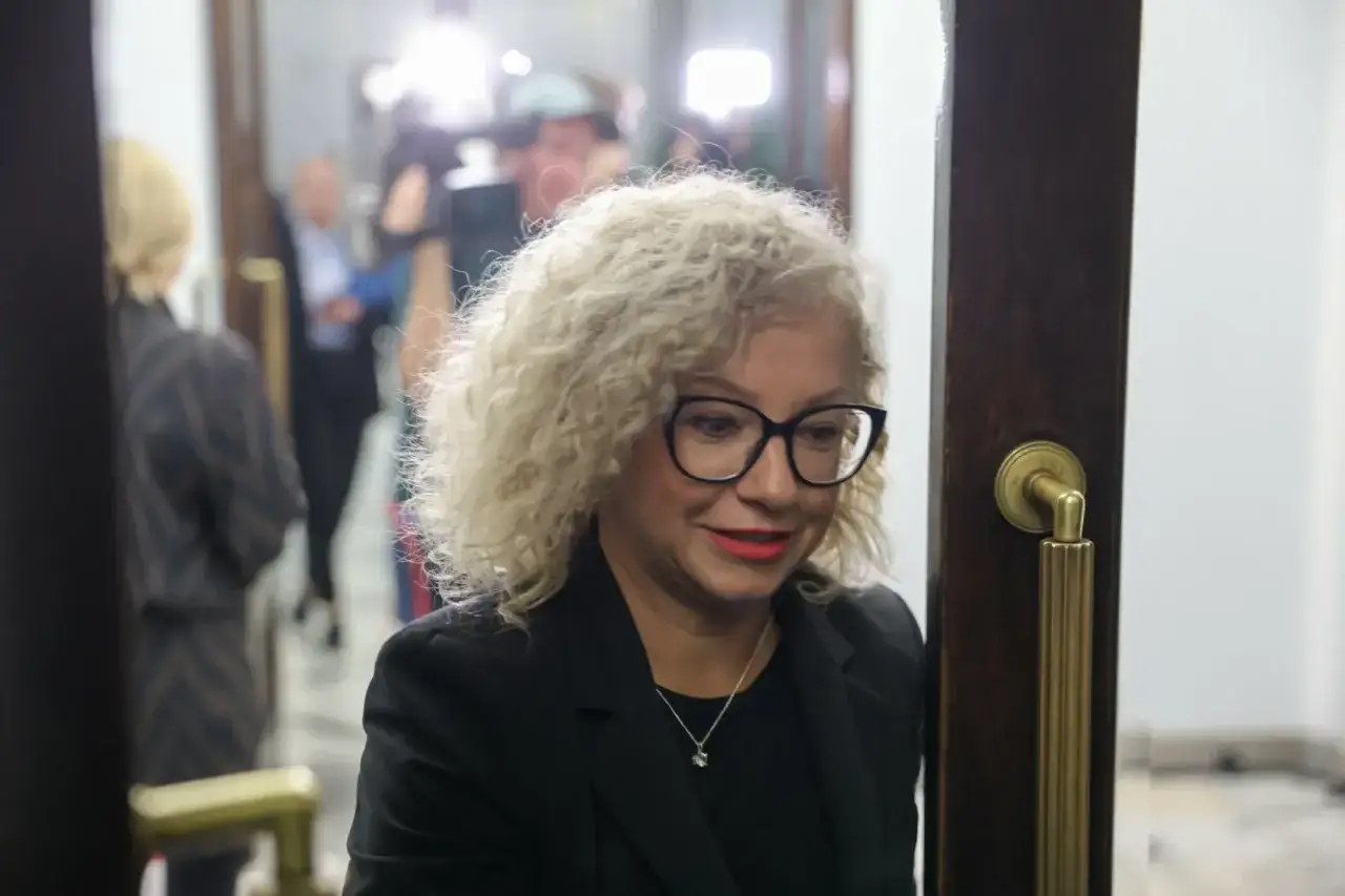 Kobieta z kręconymi blond włosami i okularami, być może w centrum dyskusji, dlaczego koalicja rządząca spiera się o ustawę dotyczącą związków partnerskich.