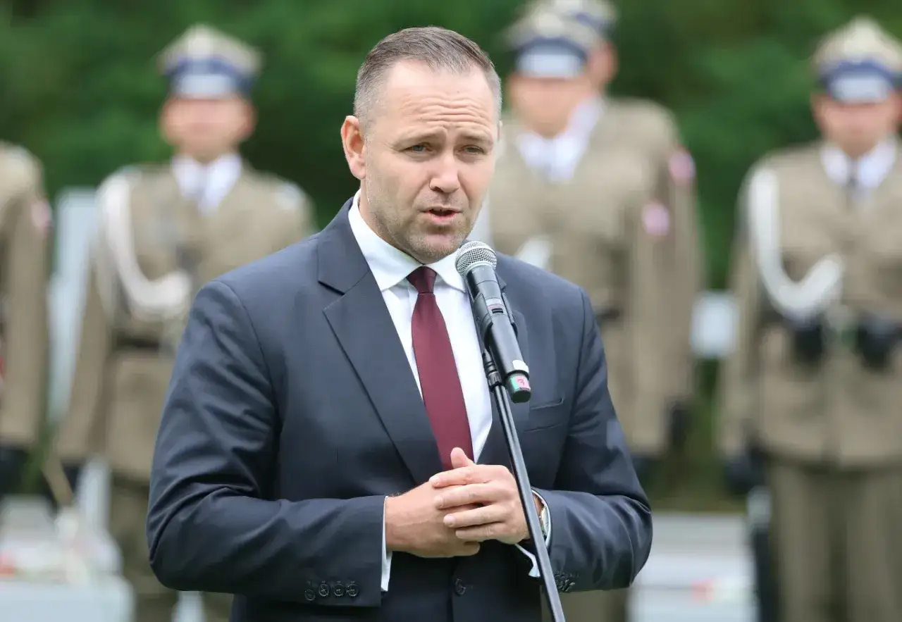 Mężczyzna w garniturze przemawia do mikrofonu, za nim stoją żołnierze. Czy wybór Karola Nawrockiego na kandydata był konsultowany z Andrzejem Dudą?