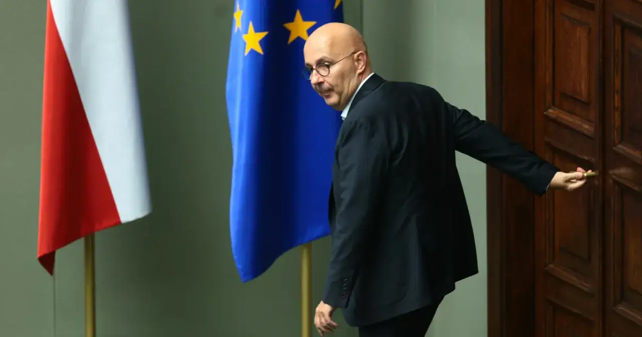 Wiceminister finansów oskarżony o korupcję w 2026 roku, wychodząc, odsłania prawdziwe powody dymisji. Obok flagi Polski i UE.