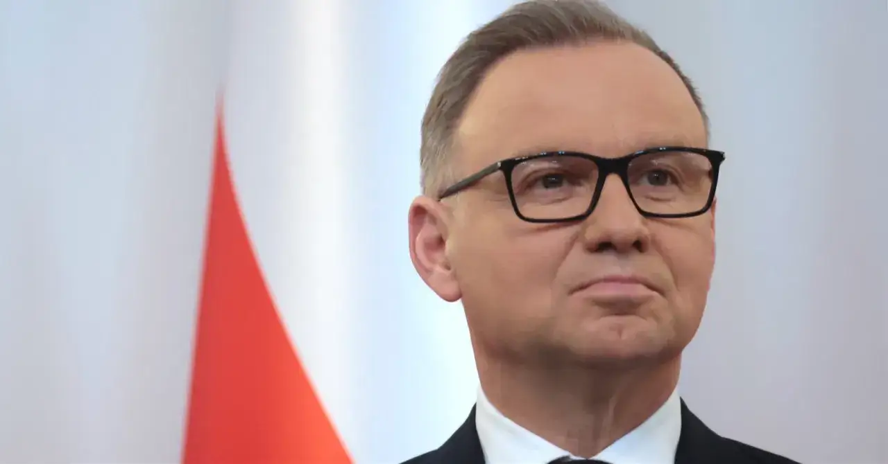 Prezydent Andrzej Duda w okularach, na tle flagi Polski. Wiele osób zastanawia się, ile zarabia prezydent Duda.