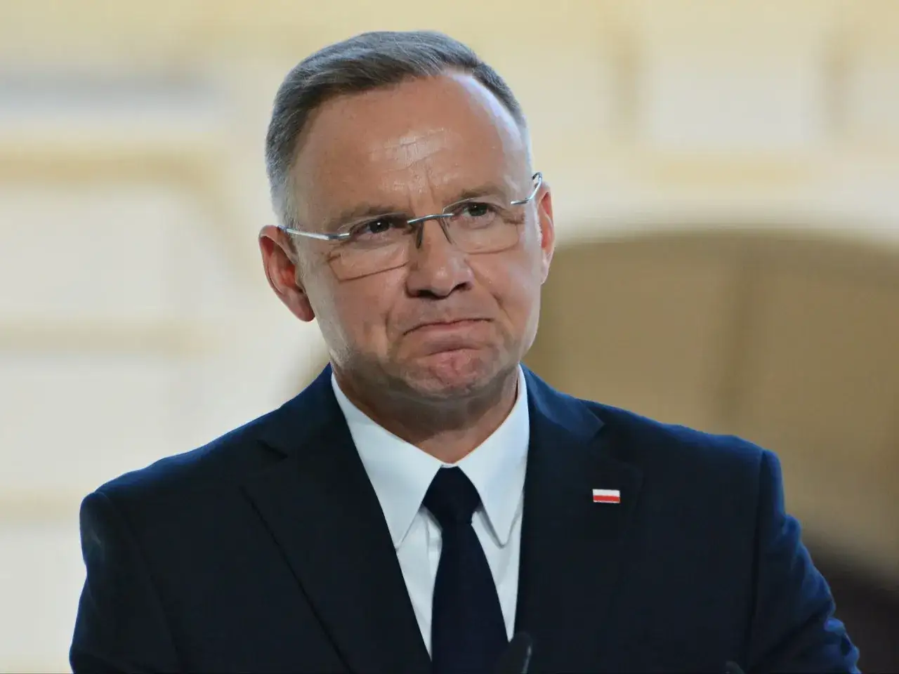 Prezydent Andrzej Duda w garniturze z wpiętą flagą Polski. Czy Andrzej Duda otrzyma specjalną odprawę finansową po zakończeniu pełnienia urzędu?