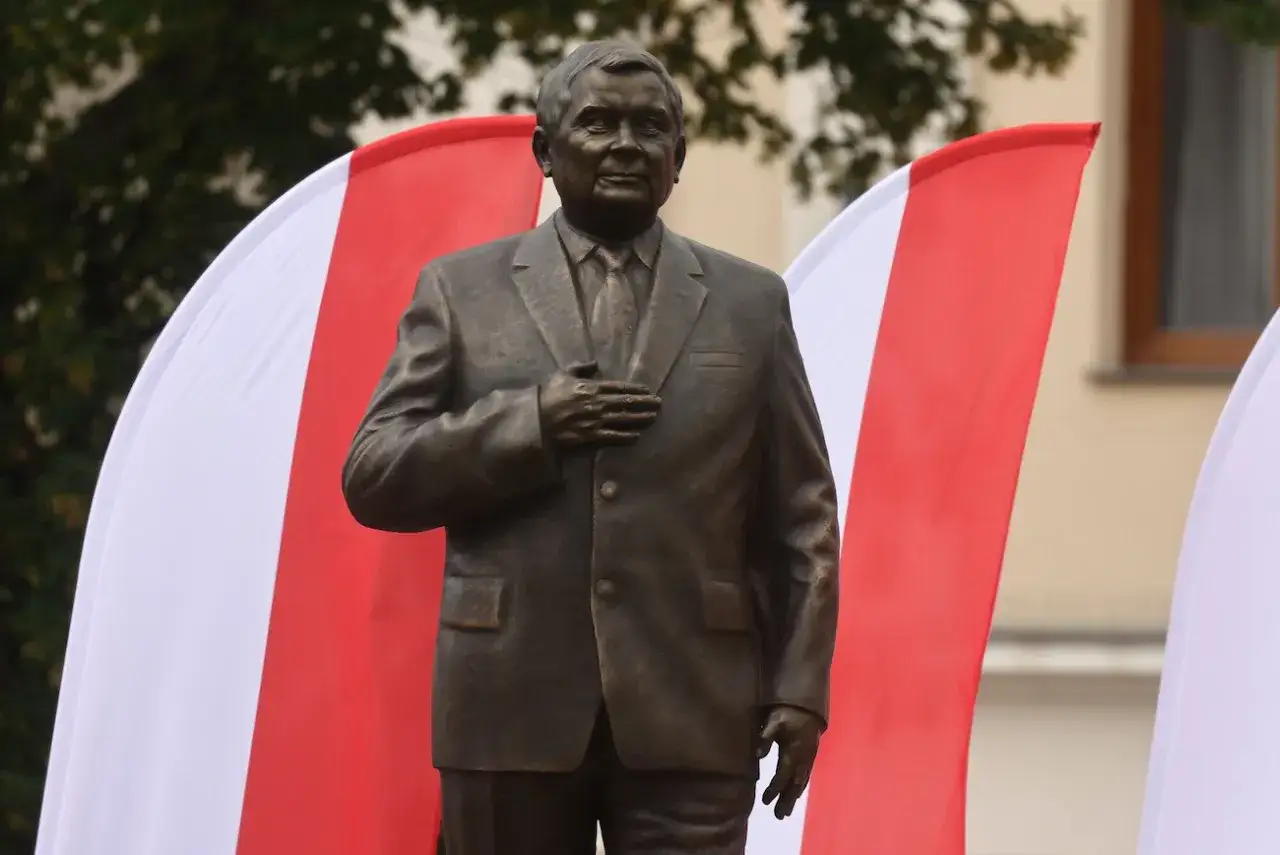 Pomnik Lecha Kaczyńskiego na tle biało-czerwonych flag. Ile jest pomników Lecha Kaczyńskiego w Polsce? Trudno policzyć wszystkie.