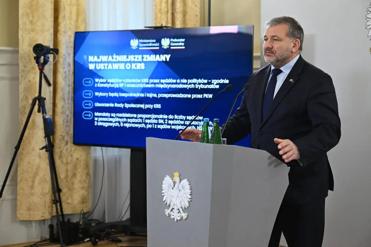 Mężczyzna przemawia na tle ekranu z informacjami o zmianach w ustawie o KRS. Dyskusja o prawdziwe przyczyny konfliktu wewnątrz KO o zasady powoływania nowej KRS.