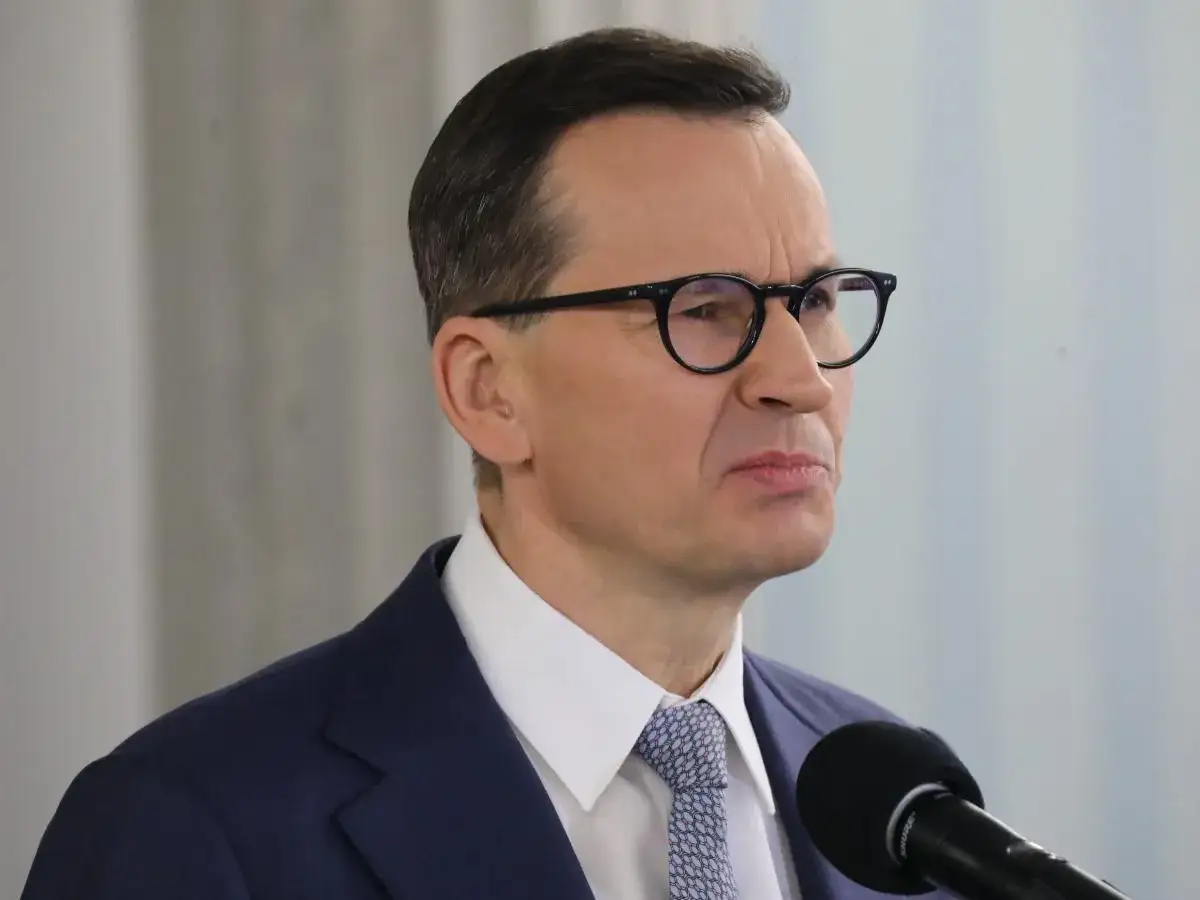 Mateusz Morawiecki w okularach, w garniturze, przed mikrofonem. Czy zastanawiasz się, ile zarabia Morawiecki?