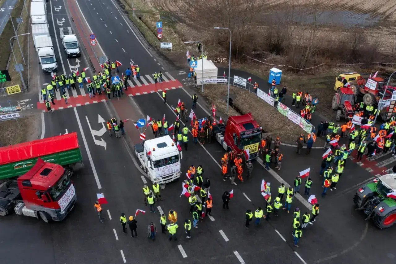 Rolnicy blokują drogę Jasło-Krosno. Czy Donald Tusk osobiście interweniował w tej sprawie w lutym? Protestujący trzymają polskie flagi i transparenty.