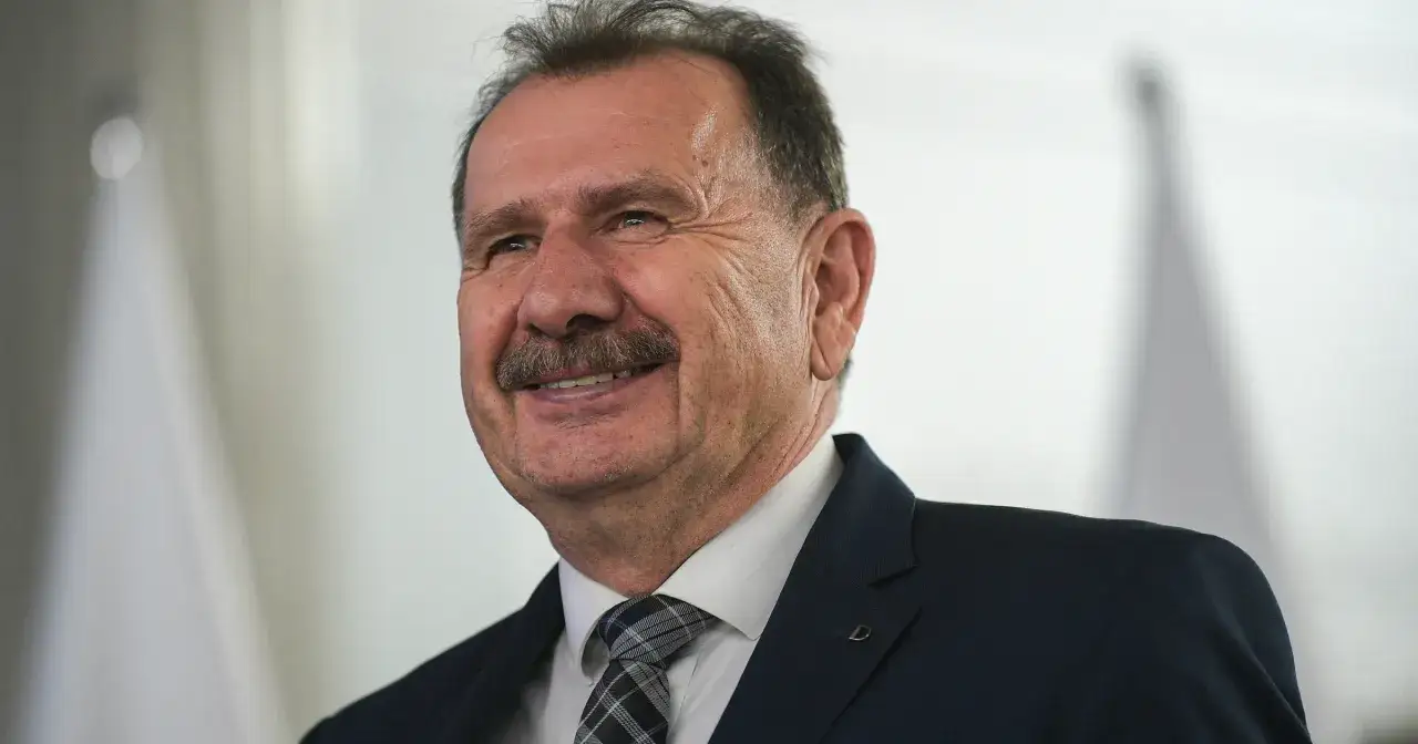 Uśmiechnięty mężczyzna w garniturze, być może wiceminister finansów, który w 2026 roku podał prawdziwe powody dymisji oskarżonego o korupcję.