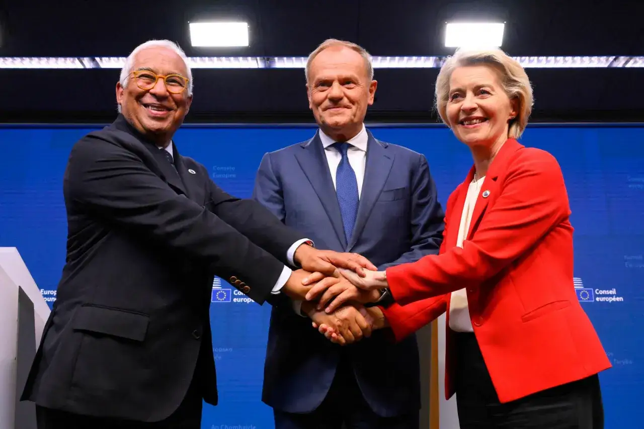 Trzej liderzy UE, w tym Donald Tusk, łączą dłonie. Jego rola w Unii Europejskiej jest kluczowa.