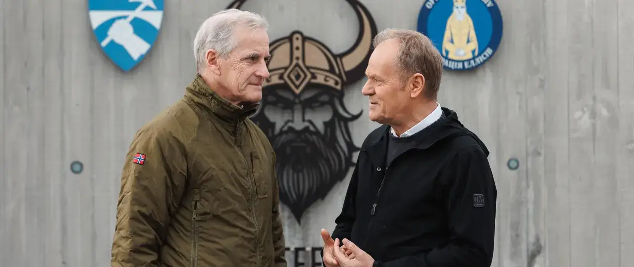 Donald Tusk i premier Norwegii rozmawiają o partnerstwie militarnym. W tle wizerunek Wikinga i flagi.