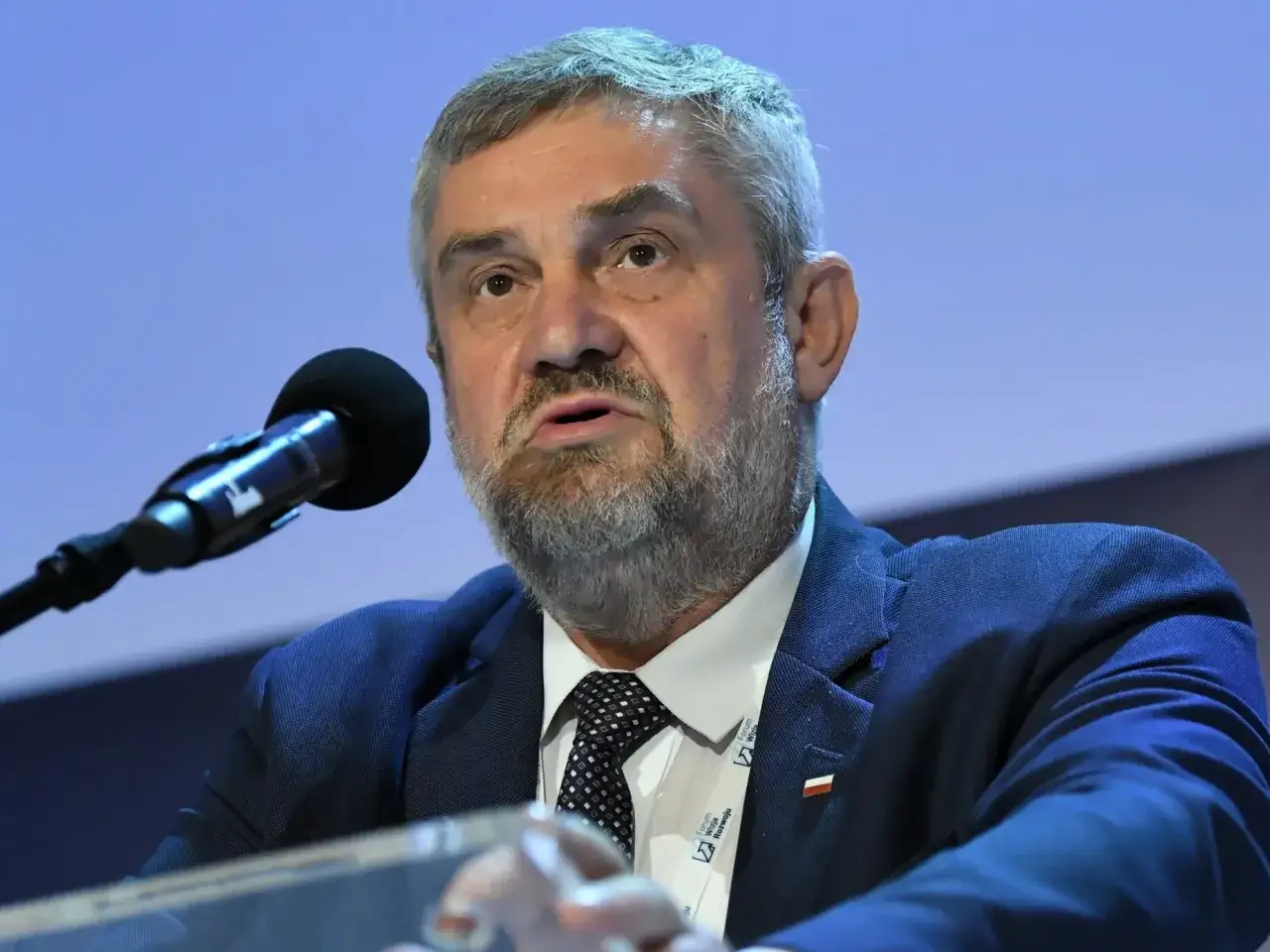 Były minister rolnictwa przemawia przy mikrofonie. Czy w 2025 roku poznamy prawdę o zarzutach prokuratorskich?